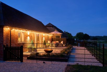 The exterior of the barn at night with the fairy lights switched on at Stable Barn, Cotswolds 
