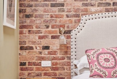 The exposed brick walls in the bedroom at The Dairy Barn, Worcestershire 