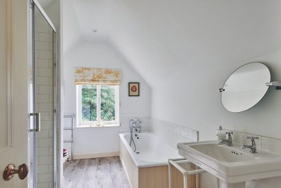 The family bathroom with a bath and shower at Withington Grange, Cotswolds