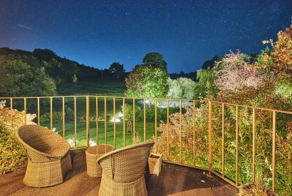 The balcony and garden view at night at Roupel Estate, Devon