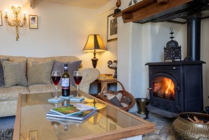 The living room with a log burner at Thatch Corner, Somerset