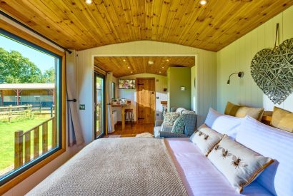 The bed overlooking the countryside view at Abberley Shepherd's Hut, Worcestershire