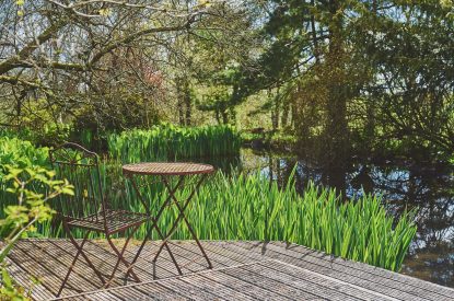 A seating area next to the pond at The Shippon Cottage, Lake District