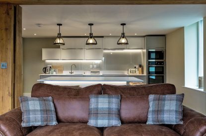 The sofa and kitchen at The Old Grain Store, Lake District