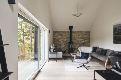The living room with a log burner at Munro Cabin, Loch Lomond