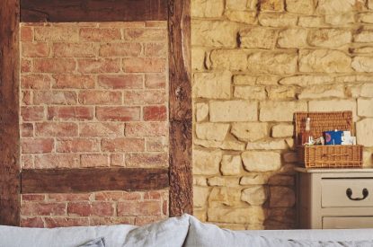 The living room with old stone walls at Ember Cottage, Cotswolds
