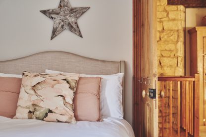 The bed and hallway at Ember Cottage, Cotswolds
