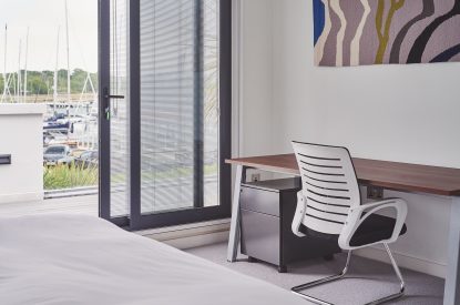 A bedroom with a balcony at The Crewhouse, Hampshire