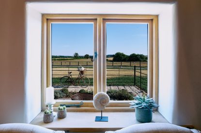 The view of a Pashley bicycle and the field beyond from the front window of Stable Barn in the Cotswolds