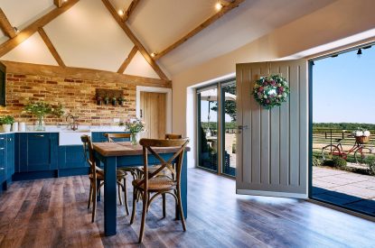 The front door, kitchen and dining table in Stable Barn, Cotswolds