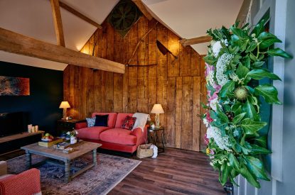The open-plan living space with the plush velvet sofa in Stable Barn, Cotswolds 