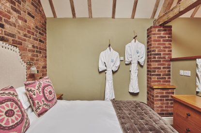 The king-size bed and fluffy robes at The Dairy Barn, Worcestershire 