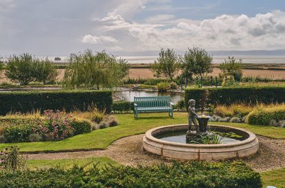 A water fountain and bench in the shared garden at Mimosa Cottage, Vale of Glamorgan