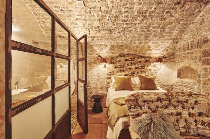 The king-size bedroom with exposed brick walls at Fritillaria Cottage, Vale of Glamorgan