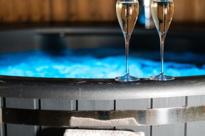 Champagne flutes beside the wood-fired hot tub at Pilgrim Cottage, Cheshire