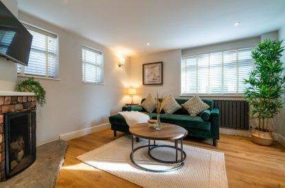 The living room with a Smart TV and a two-seater sofa at Pilgrim Cottage, Cheshire