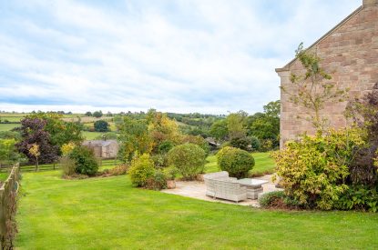 The private lawned garden with rattan furniture at Tinkers Folly, Yorkshire