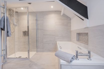 The family bathroom with a rainfall shower and bath at Rose Walls, Lake District 