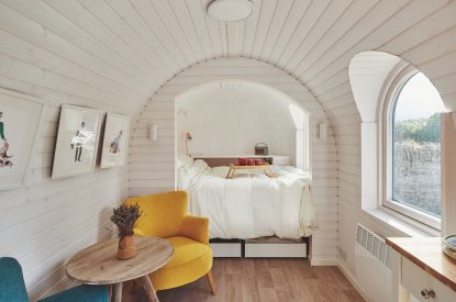 A yellow armchair with a double bed at Orchard Snug, Somerset
