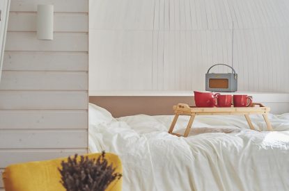 A yellow armchair and double bed at Orchard Snug, Somerset