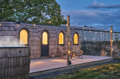 The exterior of the igluhut and wood-fired hot tub at night at Orchard Snug, Somerset