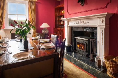 The dining room with log burner at Kittiwake House, Devon