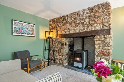 The living room with log burner at Teacher's Cottage, Gower
