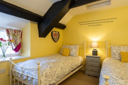A twin bedroom with beams at Sweet Shop Cottage, Somerset