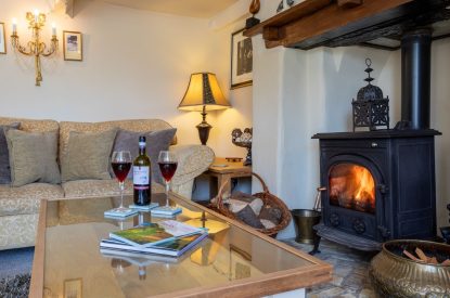 The living room with a log burner at Thatch Corner, Somerset
