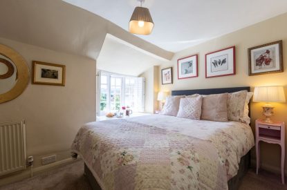 A double bedroom with a view over the garden at Thatch Corner, Somerset