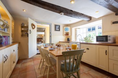 The kitchen with a large dining table at Thatch Corner, Somerset