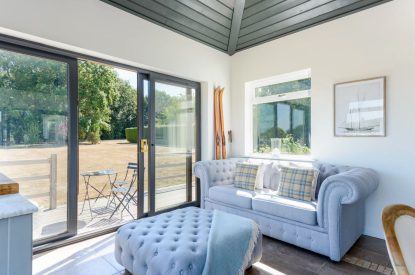 A sitting room with doors onto the garden at Brickworks and Vines, Isle of Wight