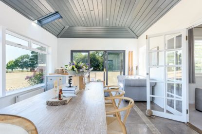 The dining room with doors leading onto the garden at Brickworks and Vines, Isle of Wight