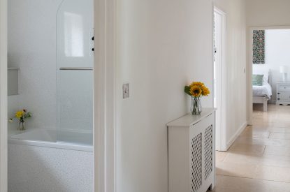 A hallway leading to a bathroom and master bedroom at Farmyard Cottage, Wiltshire
