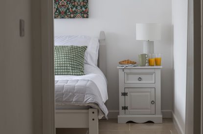A double bedroom with breakfast on the bedside table at Farmyard Cottage, Wiltshire