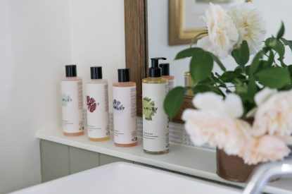 Luxury bath products on the bathroom shelf at Rambling Rose Cottage, Cotswolds