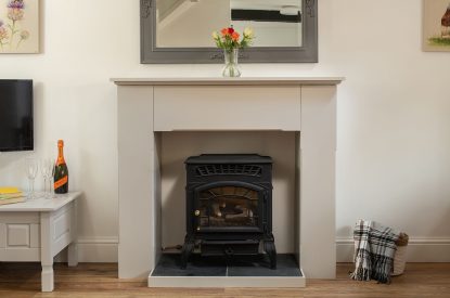 The log burner effect fireplace in the living room at The Milking Parlour, Wiltshire 