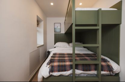 King size bed with bunk bedroom at Map Maker's Cottage, Roundstone, Galway