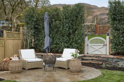 An outdoor seating area and fire pit at Beatrix Cottage, Lake District
