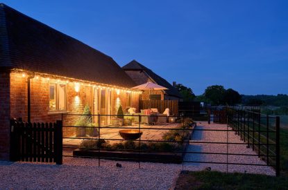The exterior of the barn at night with the fairy lights switched on at Stable Barn, Cotswolds