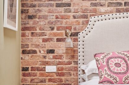 The exposed brick walls in the bedroom at The Dairy Barn, Worcestershire 