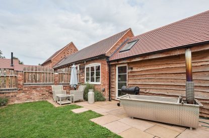The private garden with a wood-fired Swedish Hikki hot tub at The Dairy Barn, Worcestershire 