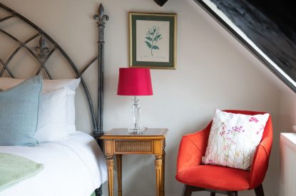 A single armchair in a double bedroom at Fig Tree Cottage, Cotswolds
