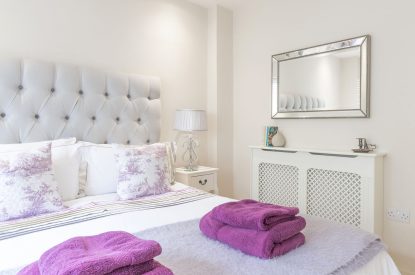 Fluffy towels on the queen-size bed at Fig Tree Cottage, Cotswolds