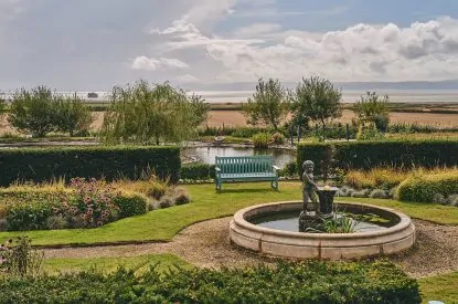 A water fountain and bench in the shared garden at Mimosa Cottage, Vale of Glamorgan