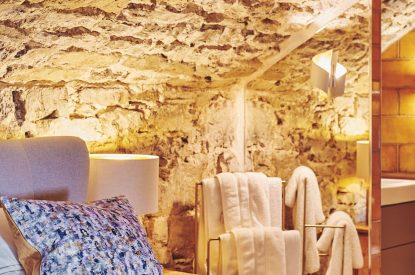 Bedroom accessories and the exposed brick walls at Bamboo Cottage, Vale of Glamorgan