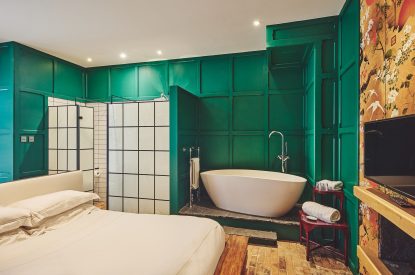 The king-size bed and bath tub at Muscari Cottage, Vale of Glamorgan