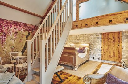 The staircase to the mezzanine level and king-size bed at Hollyhock Cottage, Vale of Glamorgan