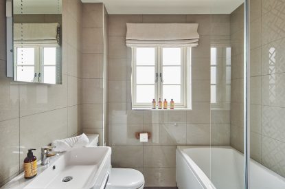 The en-suite with a shower over the bath at Stable Cottage, Worcestershire 
