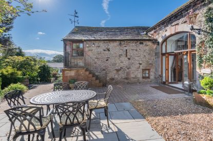 The private patio with a dining table and chairs at Rose Walls, Lake District